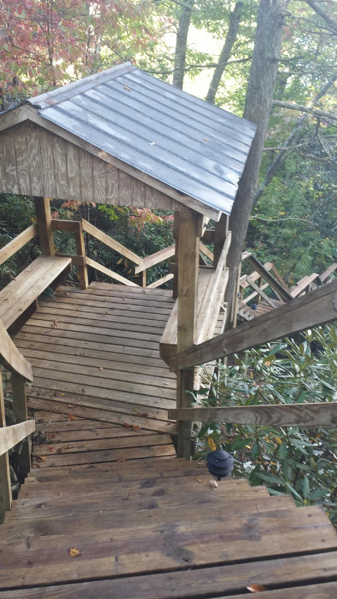 Metal roofed shelter over wooden steps on a wooded walkway — Skylight Repair & Installation work by our crew in Little York