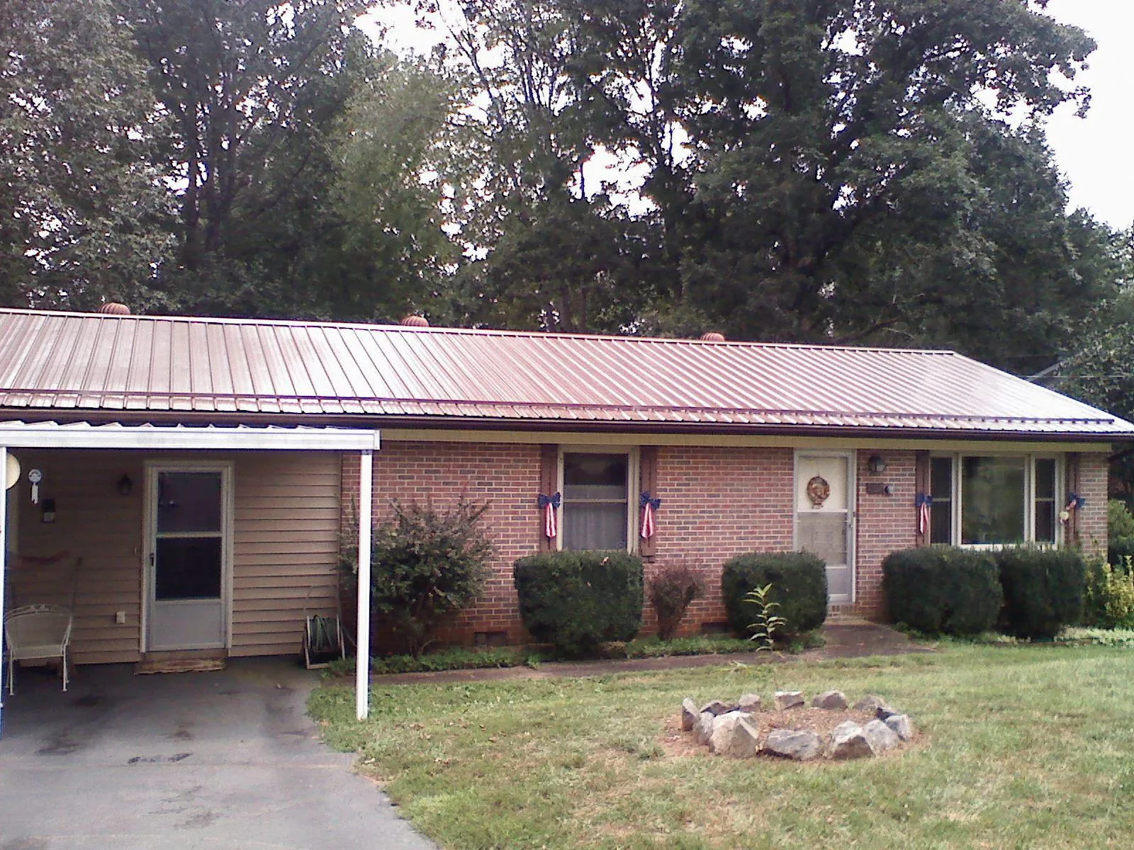 Bronze metal roof and carport on a brick ranch home — Roof Repair work by our crew in Little York